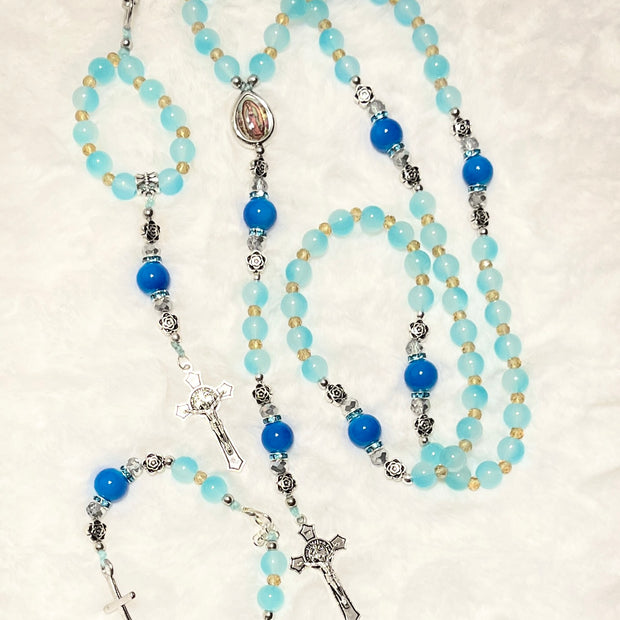 Handcrafted 3-piece Catholic gift set in aqua & cobalt blue glass. Includes a traditional 5-decade rosary, a heart clasp keychain, and a stretch faith bracelet.