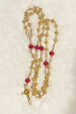Handcrafted 5-decade champagne glass rosary with red beads, a white enamel Virgin de Guadalupe center, and a matching gold St. Benedict crucifix.