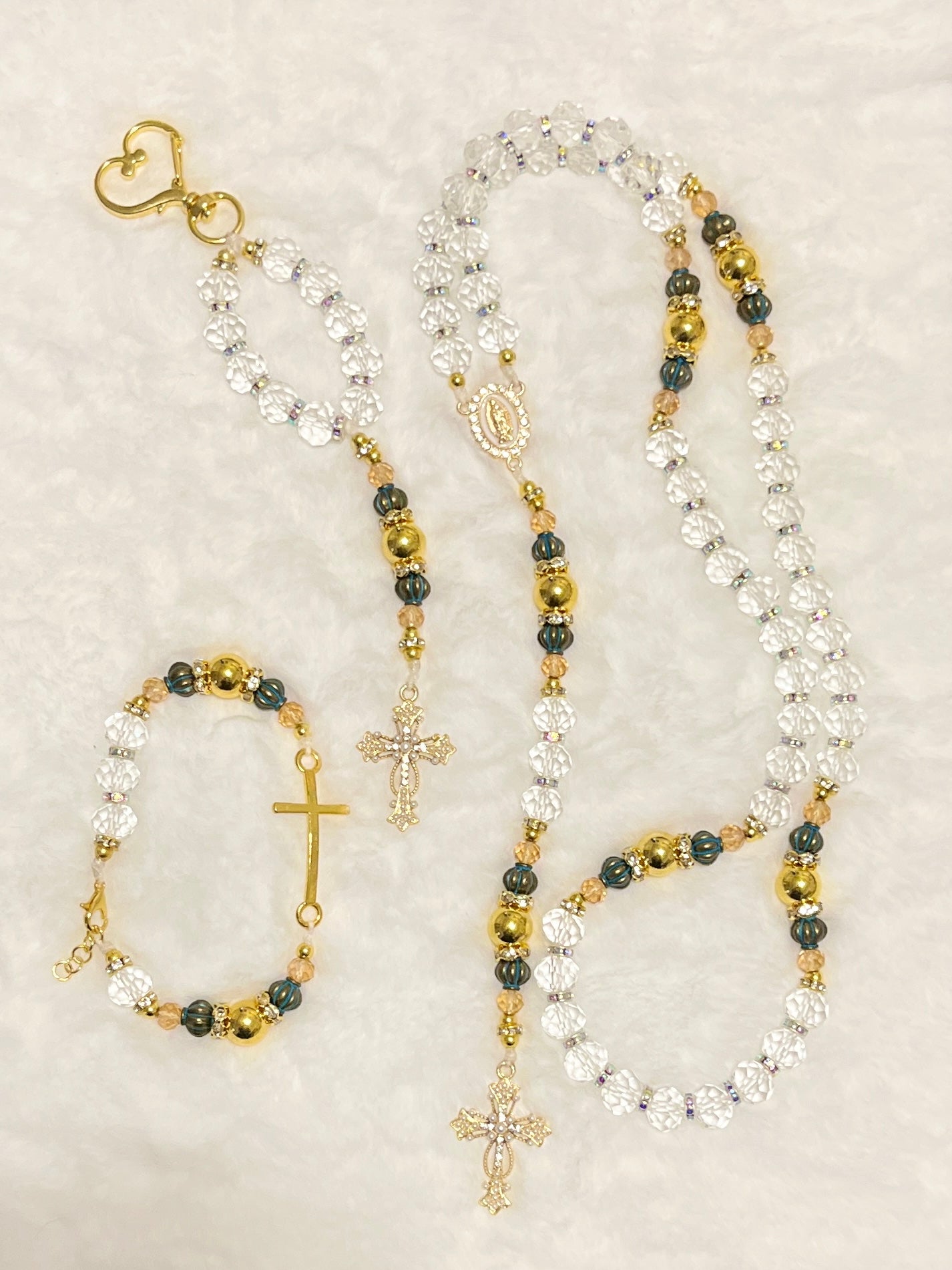 Handcrafted 3-piece Catholic gift set featuring a full 5-decade clear crystal rosary, a matching gold heart clasp keychain, and a coordinated gold cross bracelet.