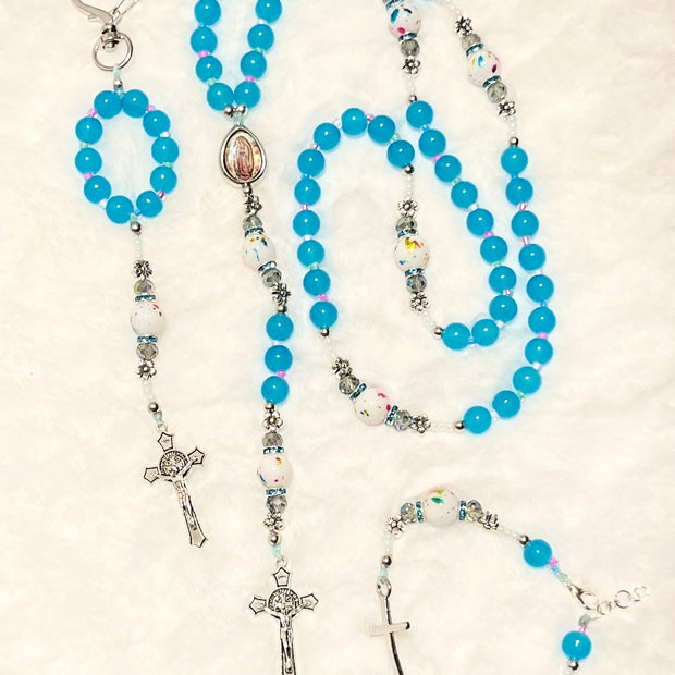  Handcrafted 3-piece Catholic gift set featuring a full 5-decade sky blue glass rosary, a matching heart clasp keychain, and a coordinated silver cross bracelet.